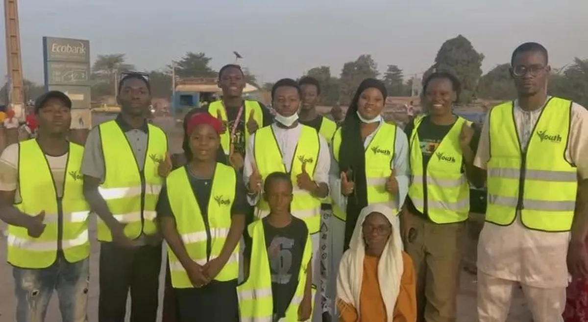 Équipe de Youth For Change – Mali en gilets jaune fluo le long d’une voie de Bamako